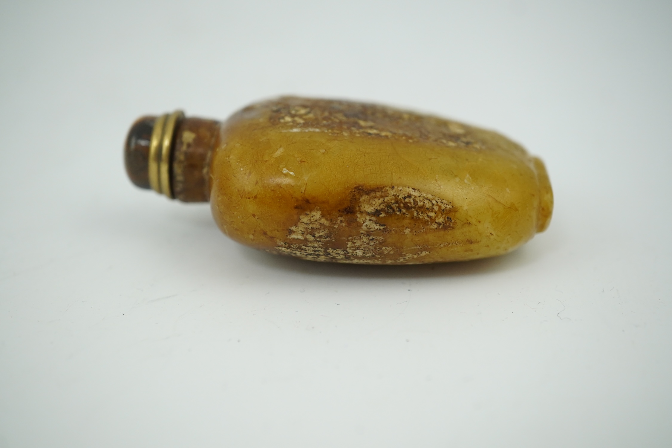 A Chinese soapstone snuff bottle with tiger's eye stopper, 8cm high. Condition - fair